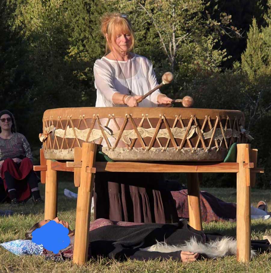 Gudrun spielt die große Mother-Drum auf einem Holzgestell